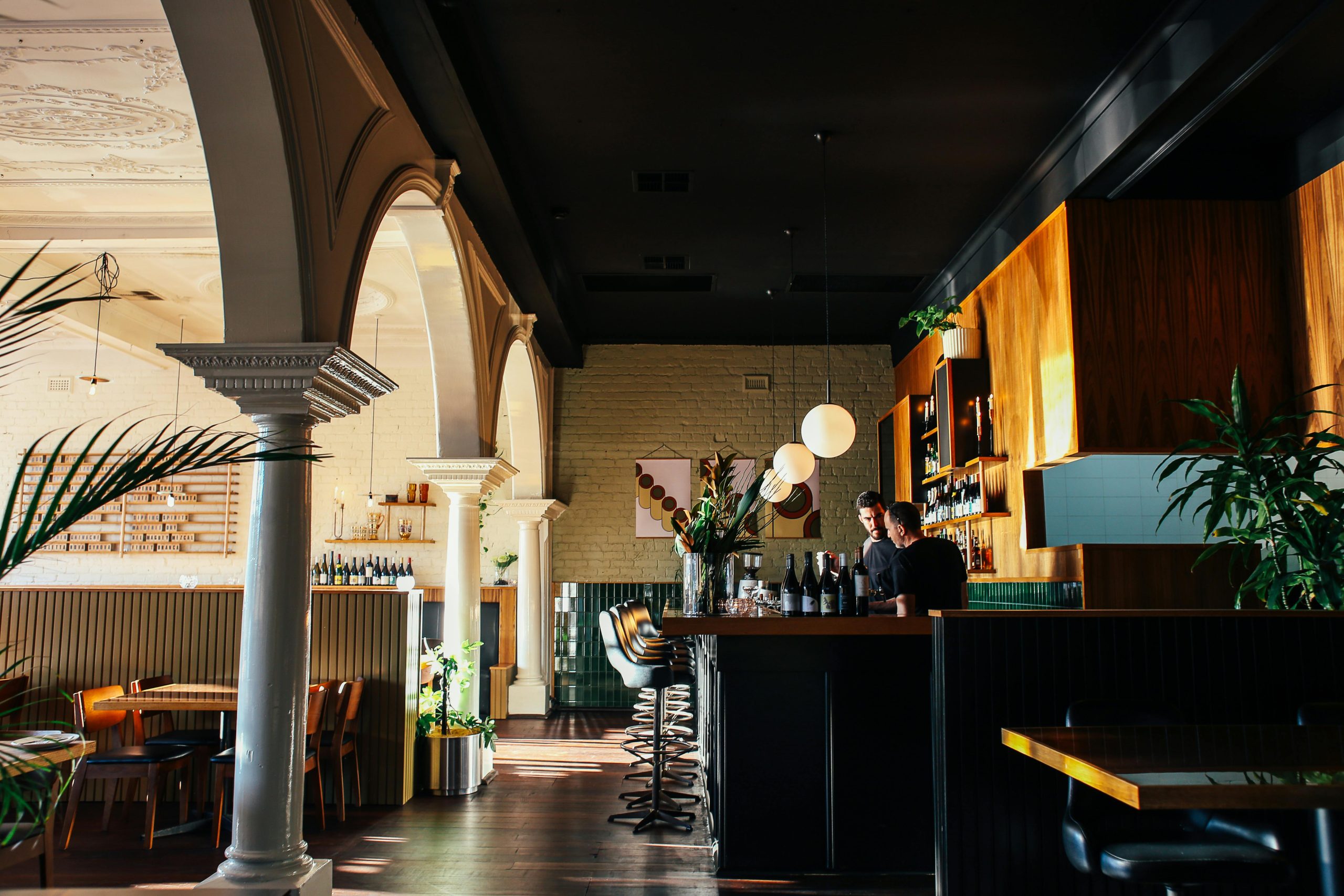 Warm and inviting bar interior featuring bartenders serving drinks in a stylish setting.
